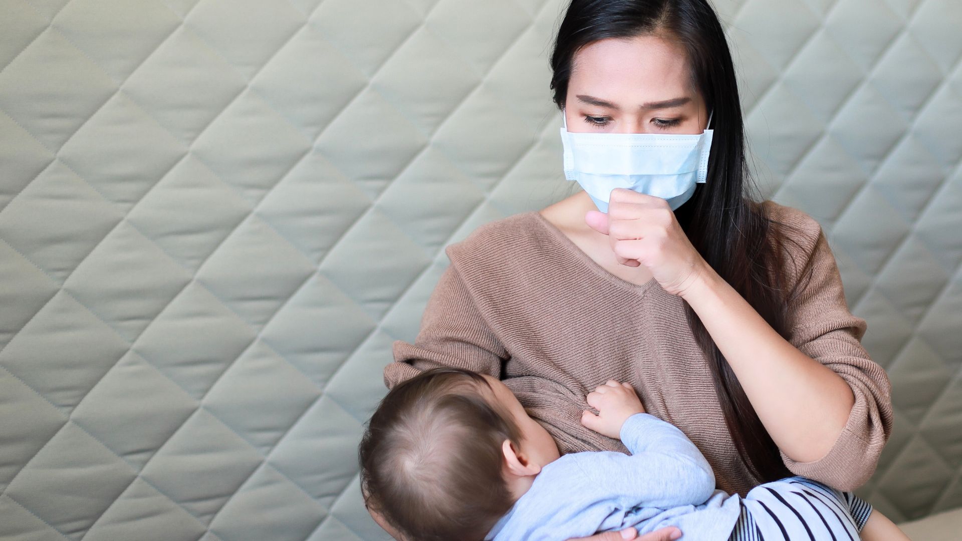 Mother wearing a face mask while breastfeeding her baby